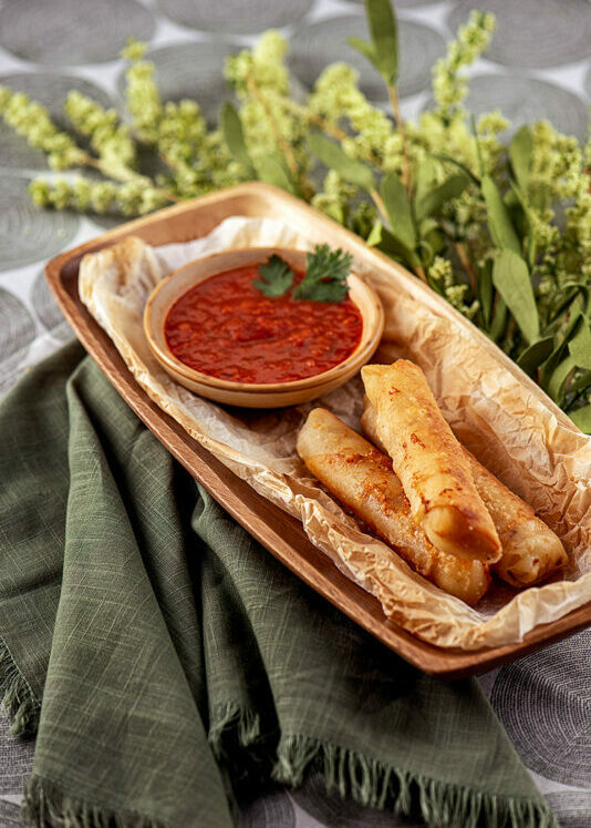 Beautifully staged and photographed tray of fried cheese sticks and marinara sauce.