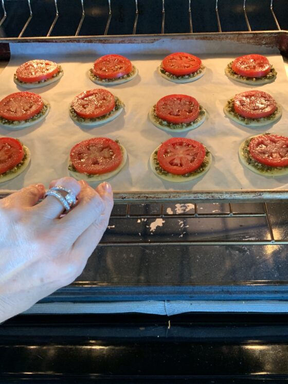 used for blog tutorial, Open oven door with tray of unbaked Tomato Puffs on top oven rack tray