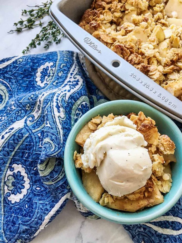 baked apple crisp with serving bowl with delicious cinnamon apple crisp .and topped with ice cream